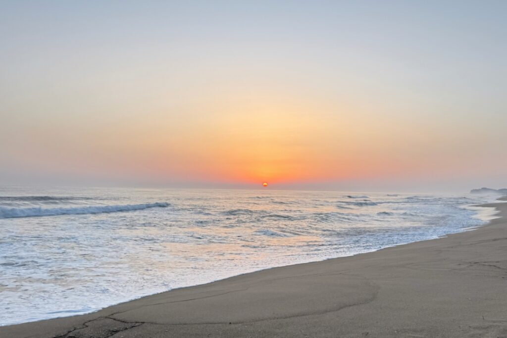 Peaceful ocean sunrise over the shoreline symbolizing clarity, reflection, and a fresh start.